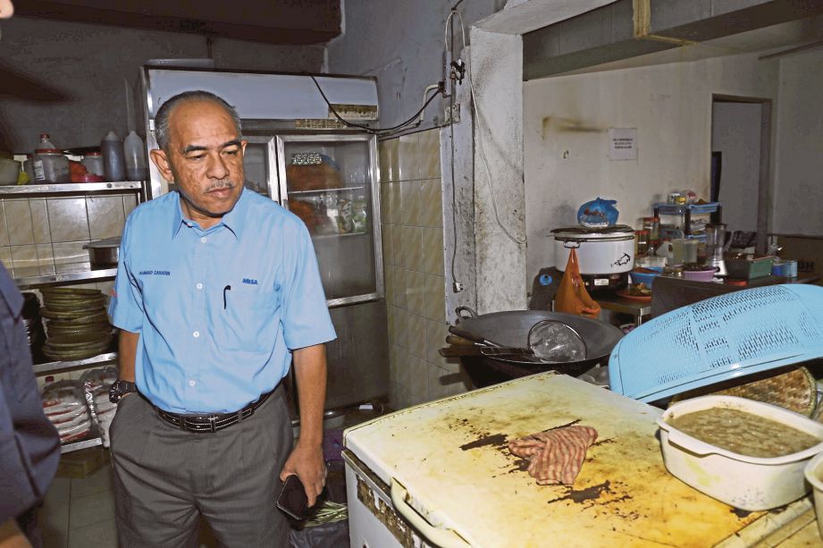 AHMAD Zaharin memeriksa bahagian dapur sebuah restoran.