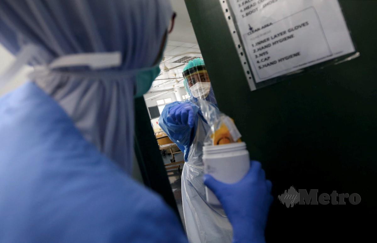 PETUGAS kesihatan terdiri daripada doktor dan jururawat mengambil sampel pesakit di dalam wad yang menempatkan pesakit Covid-19 di HKL.