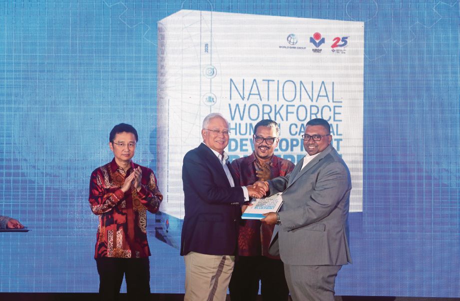 NAJIB  menerima buku Pelan Induk Pembangunan Sumber Manusia Berhad (PSMB) bagi Pembangunan Modal Insan Tenaga Kerja Kebangsaan 2018-2025 daripada  Vignaesvaran (kanan) di Majlis Makan Malam The Future Begins Tonight di Seri Perdana, Putrajaya.