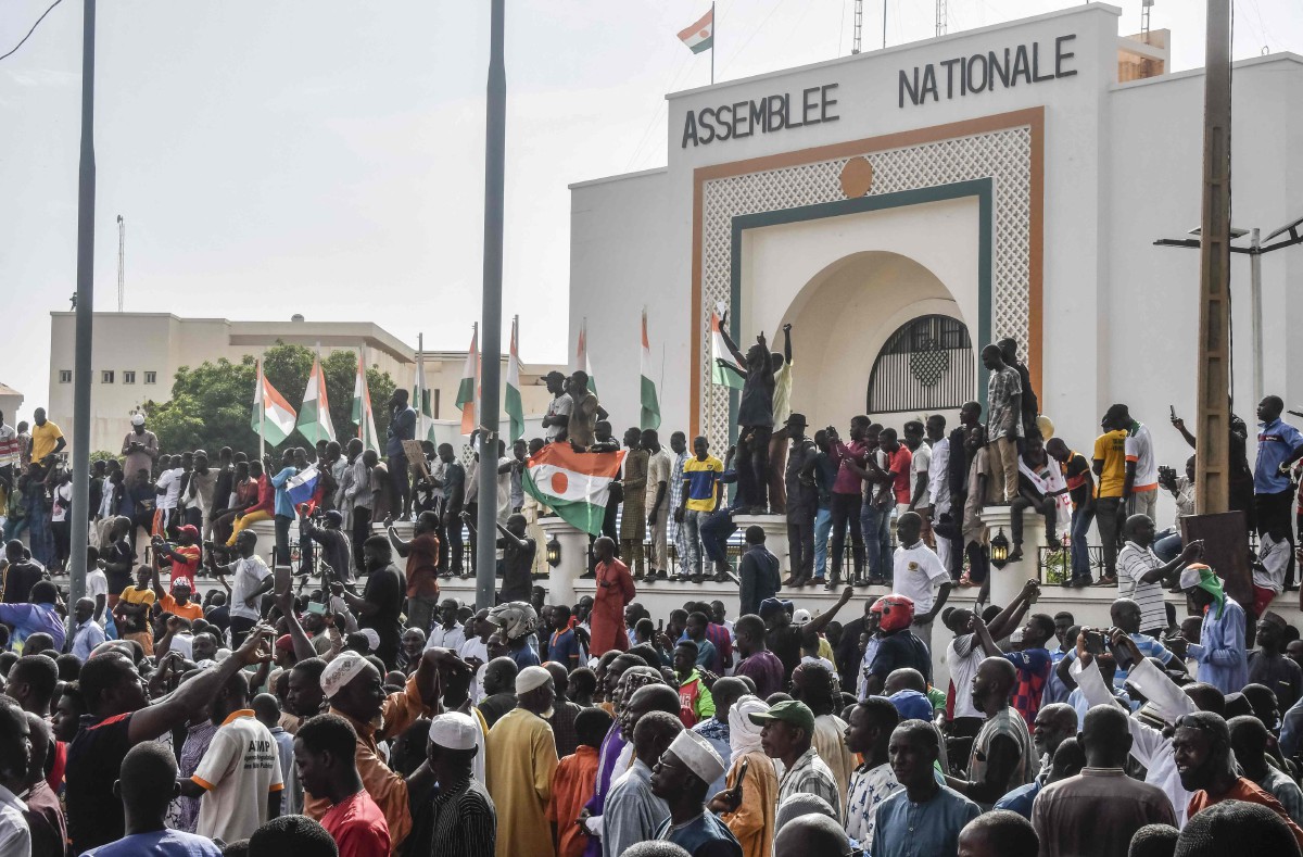 PENYOKONG mengibarkan bendera Nigeria ketika berhimpun menyokong junta Niger di Niamey. FOTO AFP.