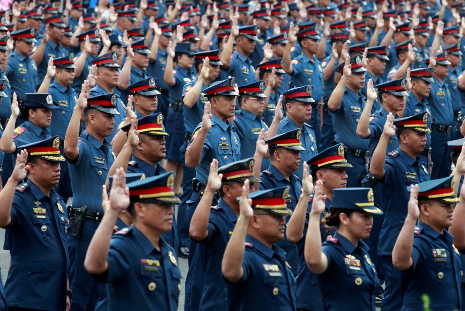 ANGGOTA polis mengangkat sumpah di Ibu Pejabat Polis Nasional Filipina di Quezon dekat Manila. - Reuters 