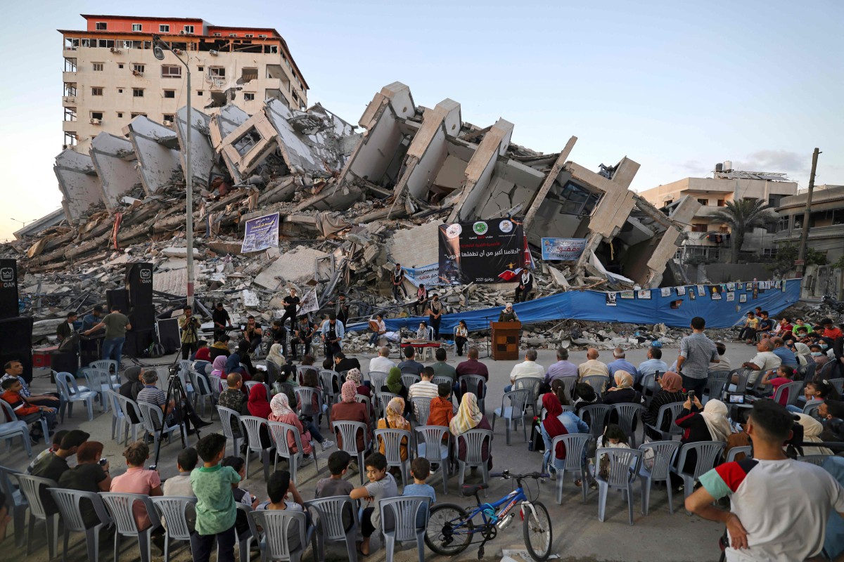 PENDUDUK Palestin mengadakan persembahan hiburan berhampiran runtuhan Menara Hanadi yang musnah susulan serangan rejim zionis Israel di Semenanjung Gaza. FOTO AFP 