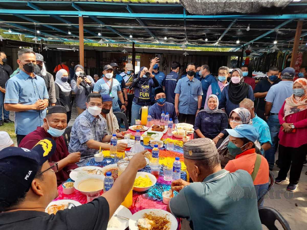 MOHAMED Azmin dan Mas Ermieyati menikmati makan tengah hari dengan komuniti di Kampung Pengkalan Balak, Masjid Tanah. FOTO Hassan Omar