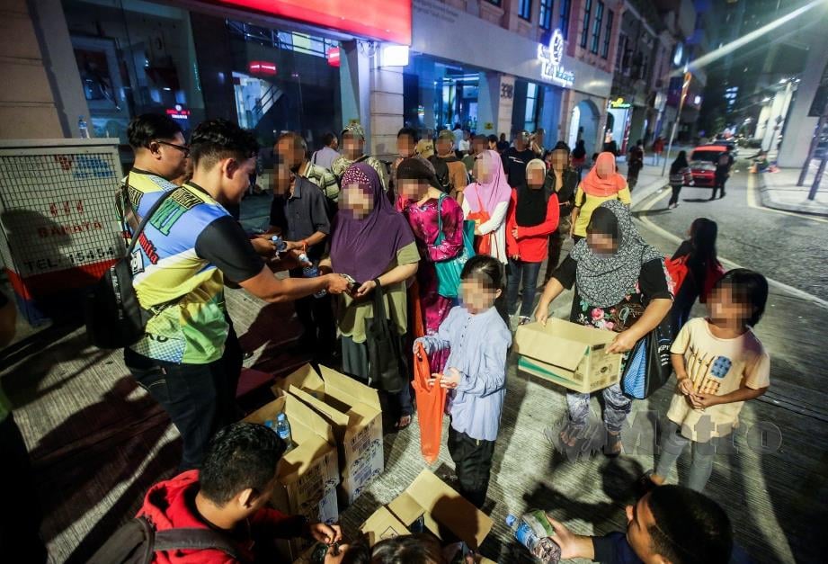 ANTARA gelandangan di sekitar Jalan Tuanku Abdul Rahman yang mendapatkan sumbangan makanan.