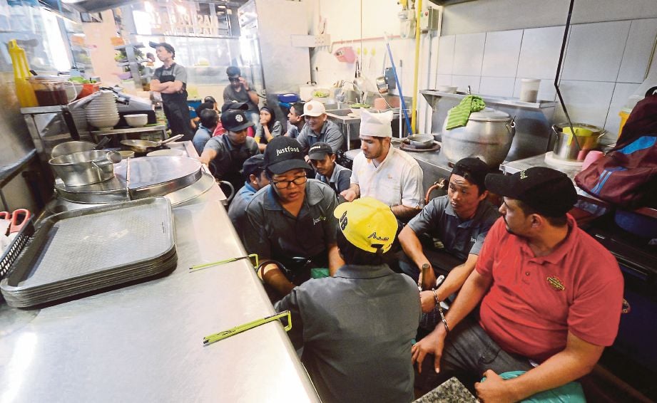 ANGGOTA imigresen menahan warga asing  untuk pemeriksaan  di premis makanan  kompleks beli-belah di Jalan Kelawai.