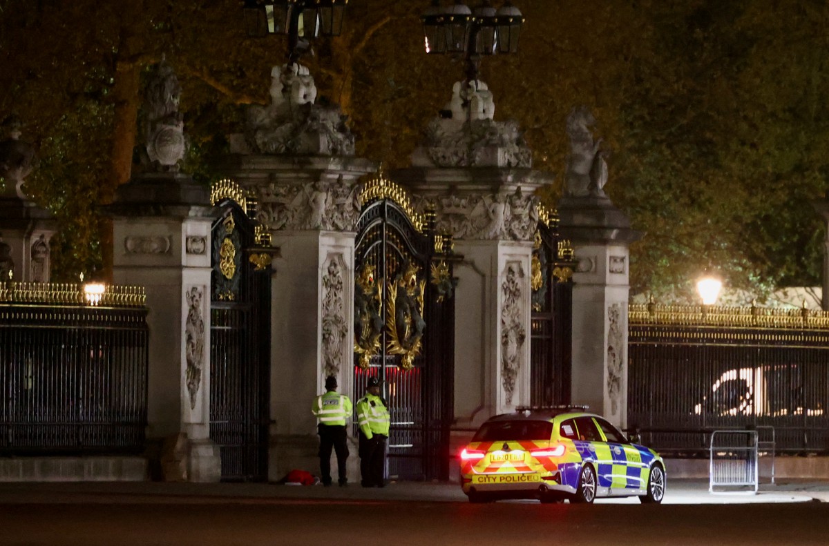 ANGGOTA polis berkawal di pagar Istana Buckingham selepas menahan seorang lelaki yang dipercayai melempar kartrij senapang patah pada 2 Mei. FOTO Reuters.