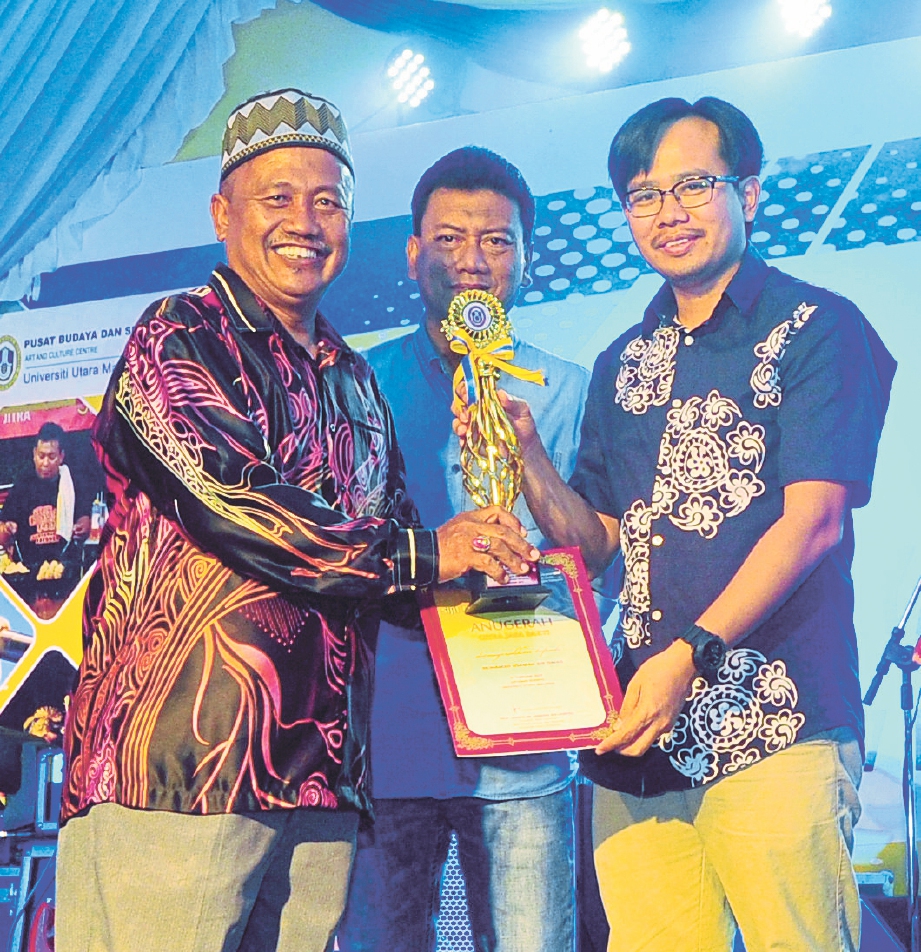 DR HENDRIK (kanan) menyampaikan Anugerah Citra Jasa Bakti kepada Mohamad Usamah Ismail disaksikan Huzaidy (tengah).