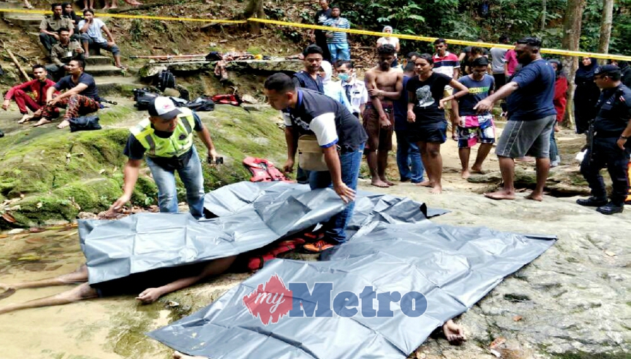 ANGGOTA polis memeriksa mayat mangsa lemas di Air Terjun Sungai Sendat, Ulu Yam, Kuala Kubu Bharu, hari ini. FOTO Ihsan JBPM
