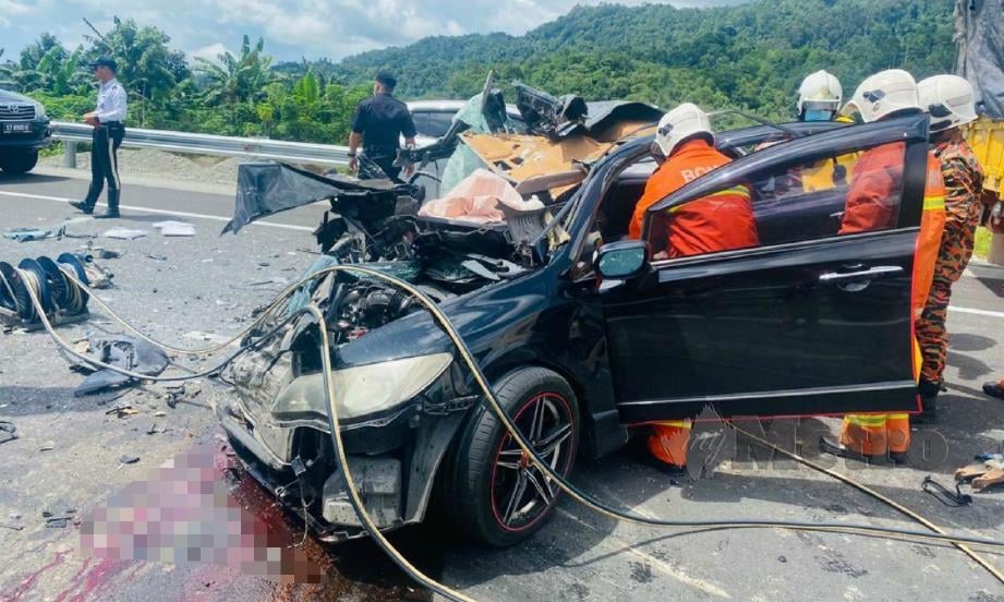 ANGGOTA bomba berusaha mengeluarkan mangsa tersepit di dalam kereta selepas kemalangan di Kilometer 22 Jalan Papar Lama-Kota Kinabalu, Papar, hari ini, FOTO Juwan Riduan. 