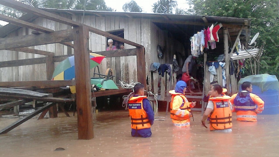 ANGGOTA APM Sabah membantu mangsa banjir di Pitas berikutan hujan berterusan sejak semalam. FOTO Bernama