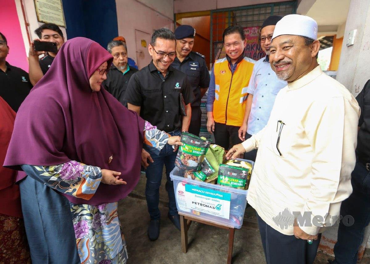 MOHD Nassuruddin (kanan) bersama Mohammad Ahmad Shazly (dua kiri) memeriksa kit makanan yang disumbangkan oleh Petronas untuk diagihkan kepada mangsa banjir. FOTO Nik Abdullah Nik Omar
