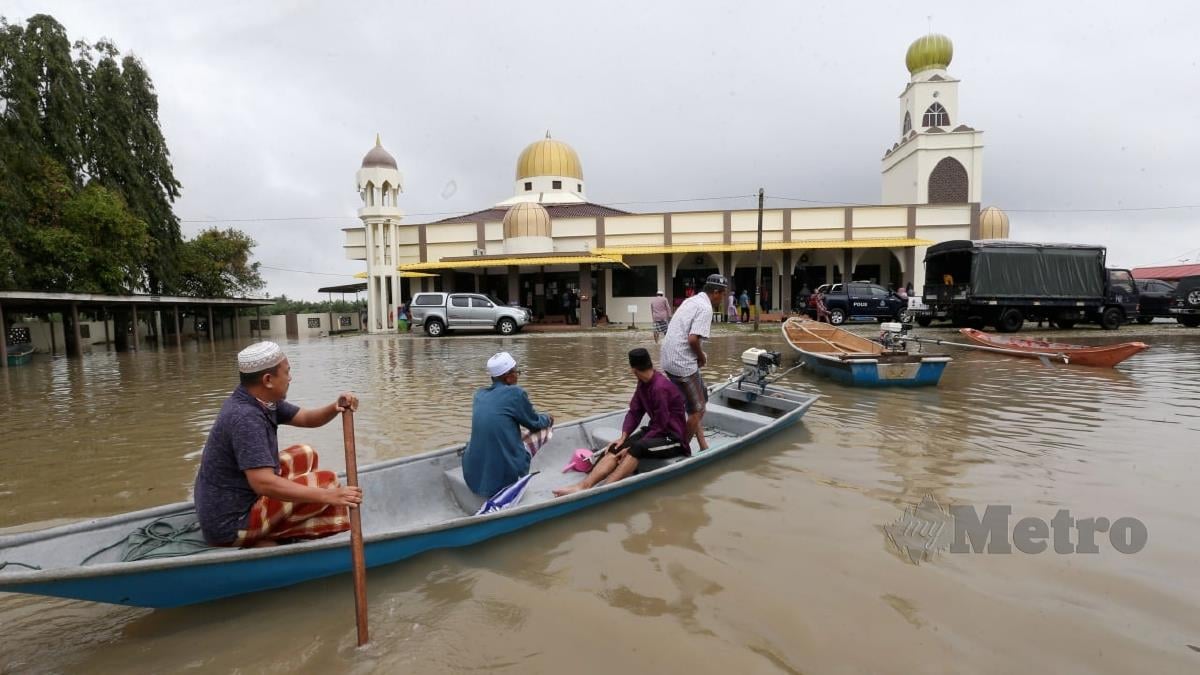 PENDUDUK meredah banjir untuk menunaikan solat Jumaat di Masjid Mukim Simpangan Hilir. FOTO Nik Abdullah Nik Omar