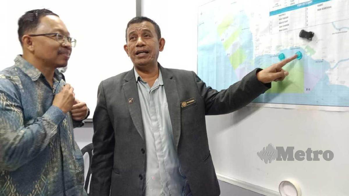 WAN Muhammad Aznan (kanan) menunjukkan gambar kawasan laut di perairan Port Dickson yang sudah dicemari biotoksin. FOTO Mohd Khidir Zakaria