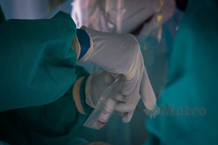 KAKITANGAN Kementerian Kesihatan Malaysia (KKM) mengambil sampel selepas membuat saringan Covid-19. FOTO Asyraf Hamzah