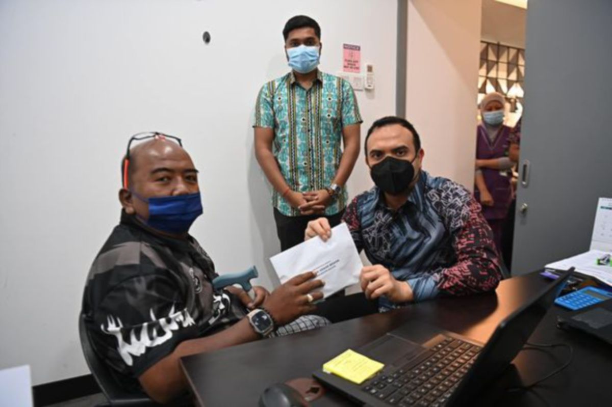 FARHAN mewakili Anwar menghulurkan sumbangan Bob Kelana Jaya. FOTO Facebook Rasmi Perdana Menteri Datuk Seri Anwar Ibrahim