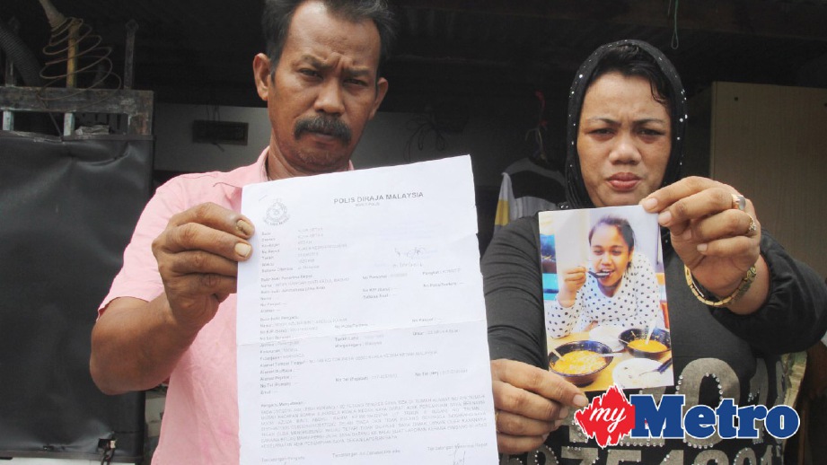 ABDULL Rahim bersama Nooraini menunjukkan salinan laporan polis dan gambar anaknya. FOTO Rahmat Othman