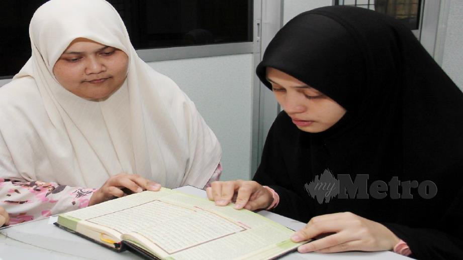 Nur Syahidah Mas (kanan) sedang membaca Al-Quran dan diajar Penolong Pendaftar Hal Ehwal Pelajar IDIP, Nor Saadah Md Hanafi@Md Zain di IDIP, Pengkalan Chepa. FOTO Nik Abdullah Nik Omar
