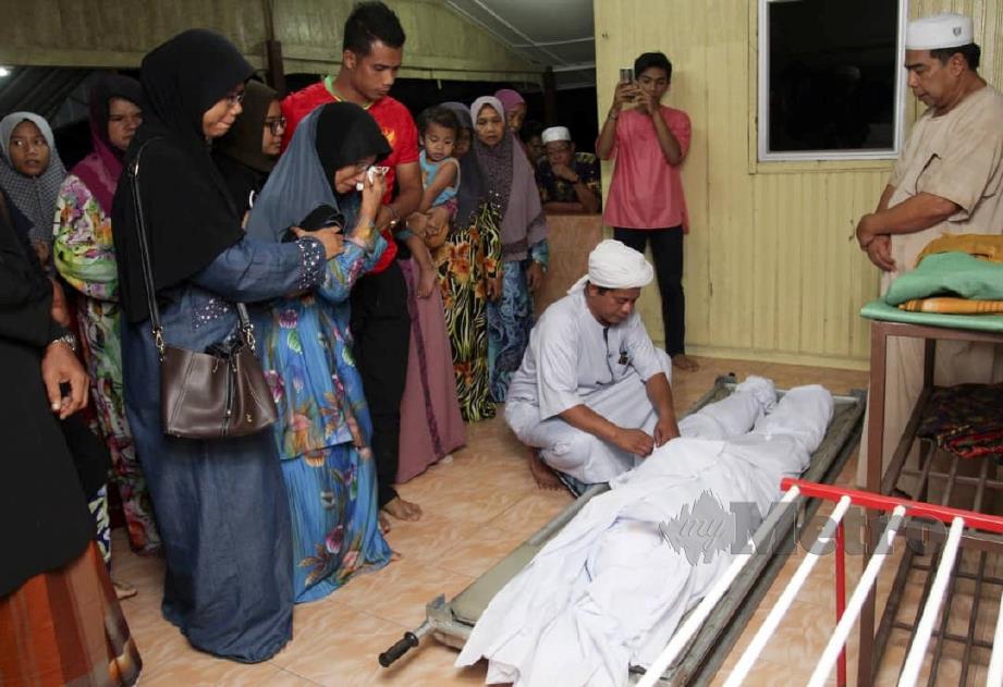 SAPINAH menahan kesedihan melihat jenazah anak dan cucunya yang maut akibat kemalangan. FOTO Nik  Abdullah Nik Omar