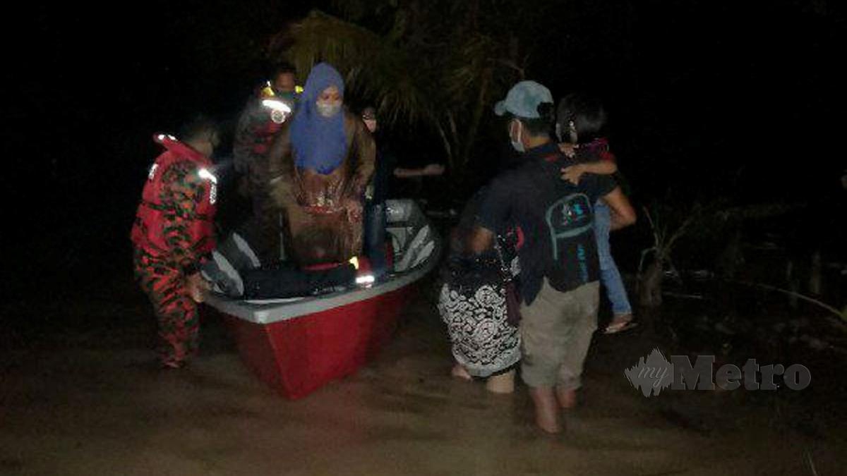 ANGGOTA Bomba menyelamatkan mangsa banjir di Kampung Laut. FOTO ihsan Bomba