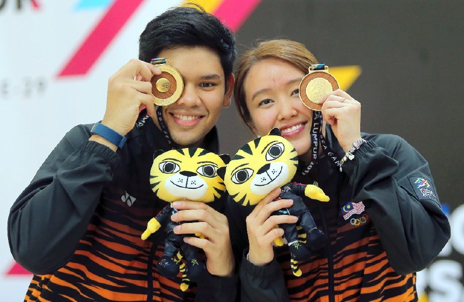 RAFIQ Ismail (kiri) dan Sin Li  memperagakan pingat emas yang dimenangi dalam acara boling beregu campuran. -Foto DANIAL SAAD 