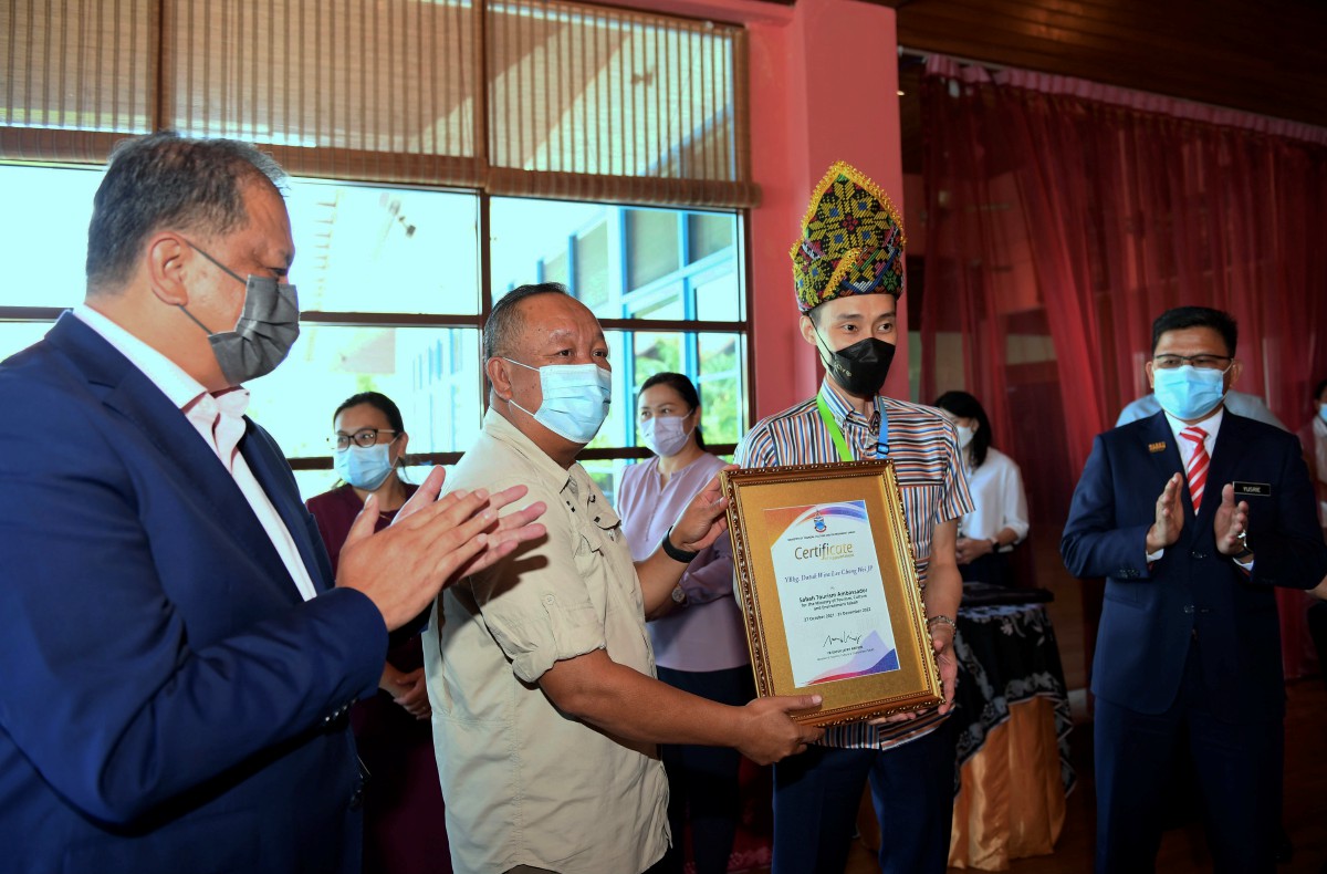 JAFRY Ariffin (dua dari kiri) menyampaikan sijil kepada Chong Wei yang dilantik sebagai Duta Pelancongan Sabah daripada Kementerian  Pelancongan Kebudayaan dan Alam Sekitar Sabah hari ini. FOTO BERNAMA