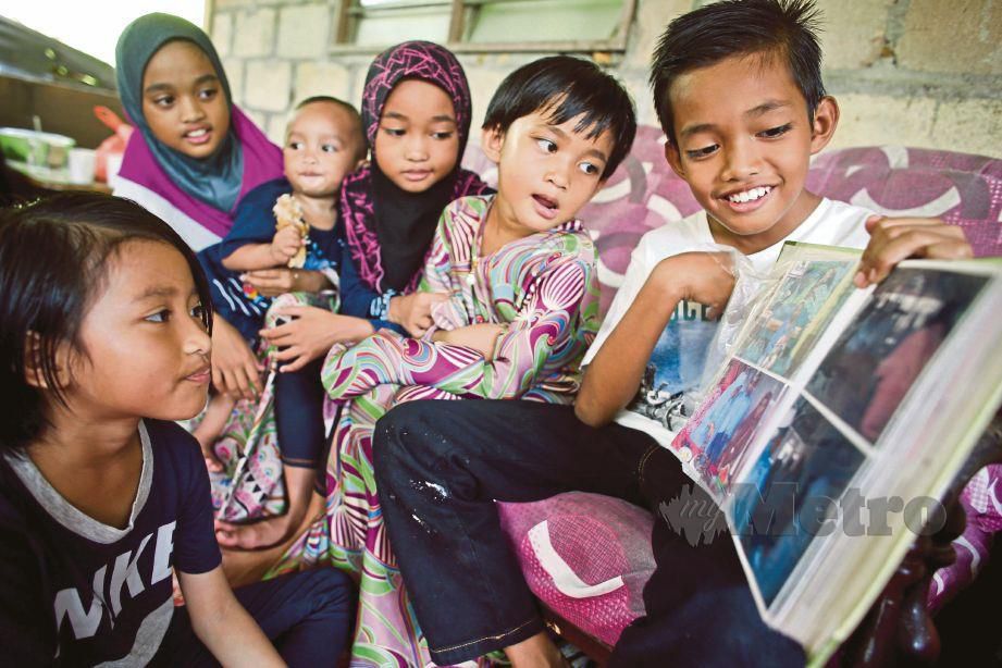 MOHD Aiman Syazwan  (kanan) bersama adiknya  melihat gambar arwah ibunya di kediaman mereka  di Kampung Legong Ulu Kota, Rembau.
