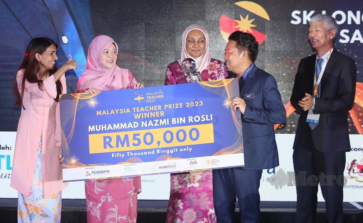 FADHLINA (dua, kiri) menyampaikan hadiah kepada Cikgu Muhammad Nazmi yang diumumkan pemenang Malaysia Teacher Prize 2023, hari ini. FOTO Saifullizan Tamadi. 