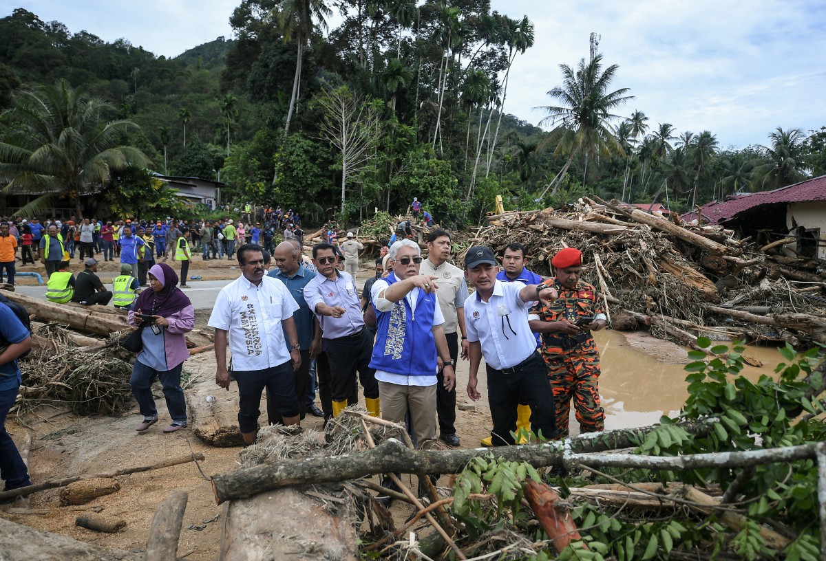 MOHAMMAD Anuar yang mewakili Perdana Menteri meninjau keadaan Sungai Latar Celak, Kupang yang dipenuhi timbunan kayu balak selepas banjir semalam. FOTO Bernama.