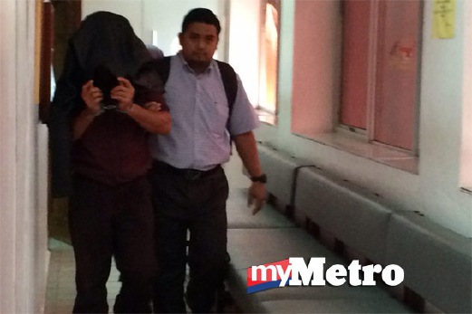TERTUDUH dibawa keluar dari Mahkamah Sesyen. FOTO Syahirah Abdullah