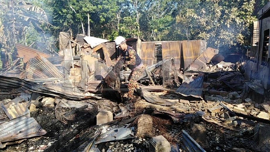 PEGAWAI Forensik JBPM Kedah melakukan siasatan di rumah yang terbakar di Kampung Tok Gelam, Mukim Naga. FOTO Zuliaty Zulkiffli