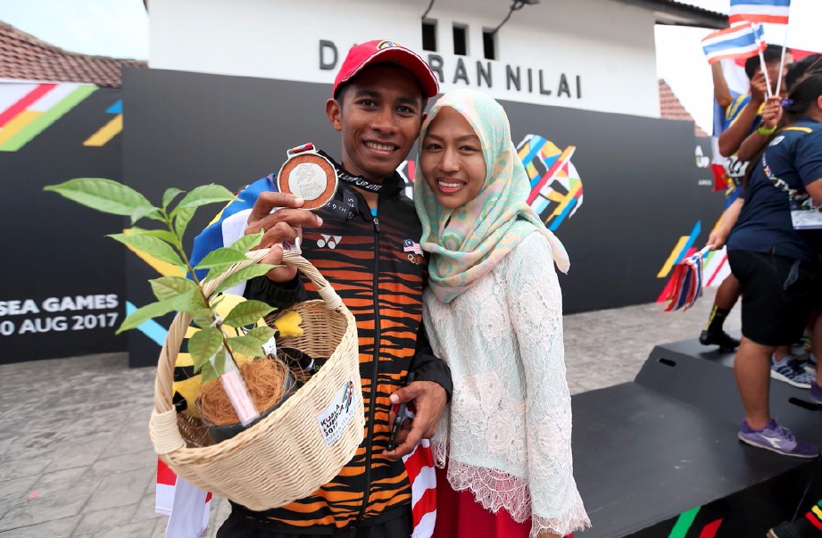  MOHD Shahrul bergambar bersama isterinya, Anis Natasha Ishak selepas meraih pingat perak dalam acara lumba basikal lebuhraya lepas beramai-ramai individu lelaki. -Foto LUQMAN HAKIM ZUBIR 