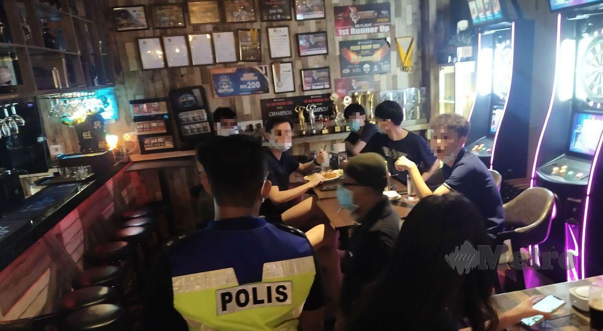 POLIS memeriksa enam individu yang gagal mematuhi SOP penjarakan fizikal ketika mengunjungi sebuah pub di Taiping Centre Point, malam tadi. FOTO Muhammad Zulsyamini Sufian Suri