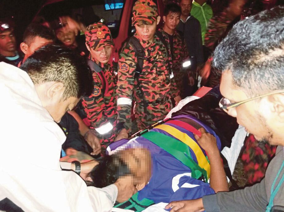 ANGGOTA penyelamat membawa Mohd Faiz turun sebelum dibawa ke hospital.
