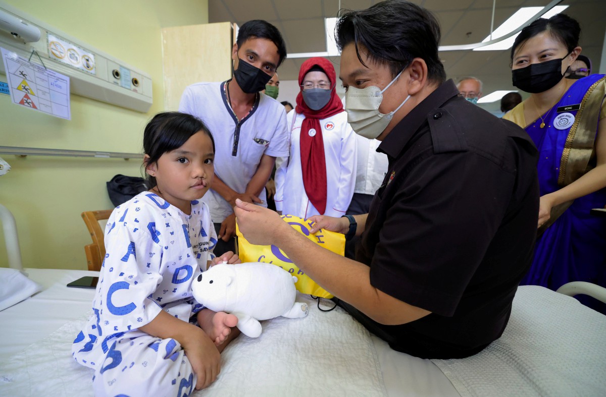 LUKANISMAN melihat dengan lebih dekat keadaan bibir Wamisa Abdullah yang sumbing ketika melawat wad kanak-kanak Hospital Lahad Datu selepas perasmian inisiatif GSOI. FOTO Bernama.