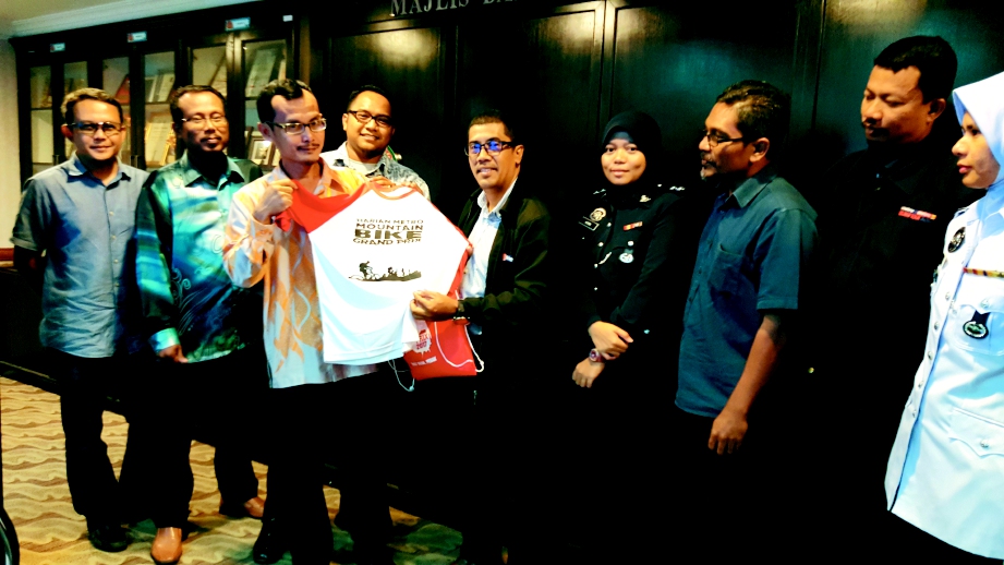 Noor Azam  (empat dari kanan) menyerahkan baju MTBGP kepada  Azman  (tiga dari kiri)  di MDHS, Kuala Kubu Bharu, semalam.  