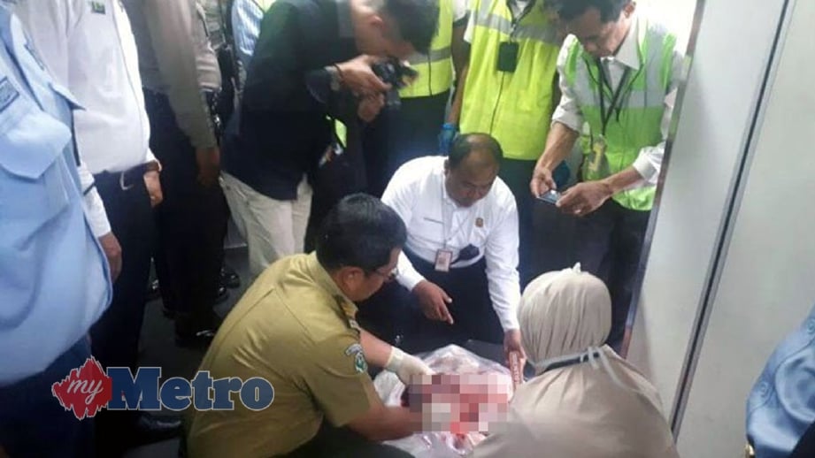 ANGGOTA polis memeriksa mayat bayi yang ditemui dalam tong sampah tandas pesawat di Jakarta. FOTO Warta Kota