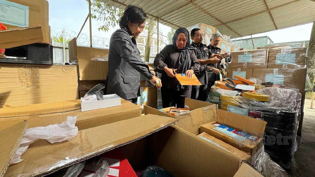 LILIS (tengah) menggunting produk tiruan yang dirampas pada Program Pelupusan Ekshibit KPDN. FOTO Nur Aisyah Mazalan