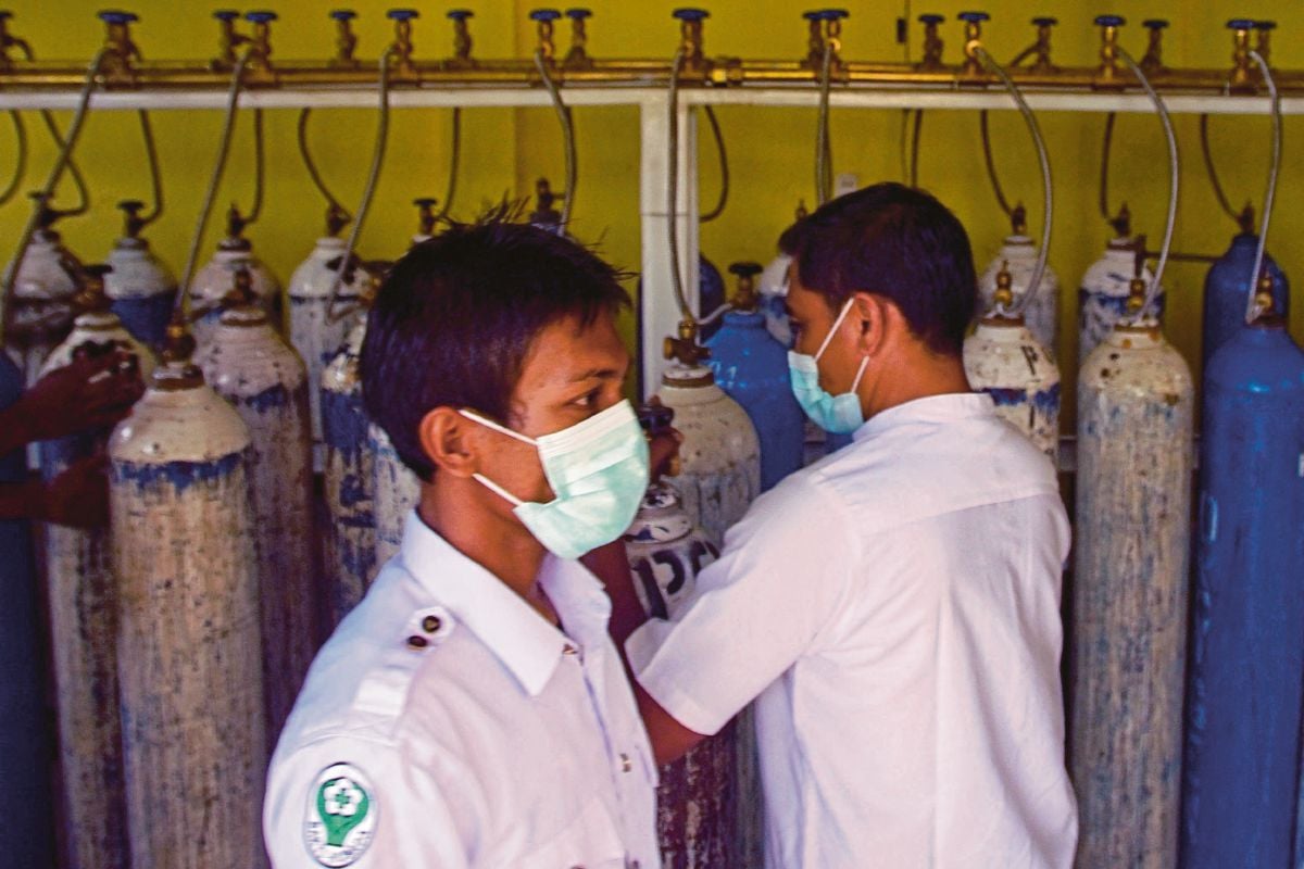 PETUGAS kesihatan memunggah tangki oksigen di sebuah hospital di Lhokseumawe, Aceh. FOTO 