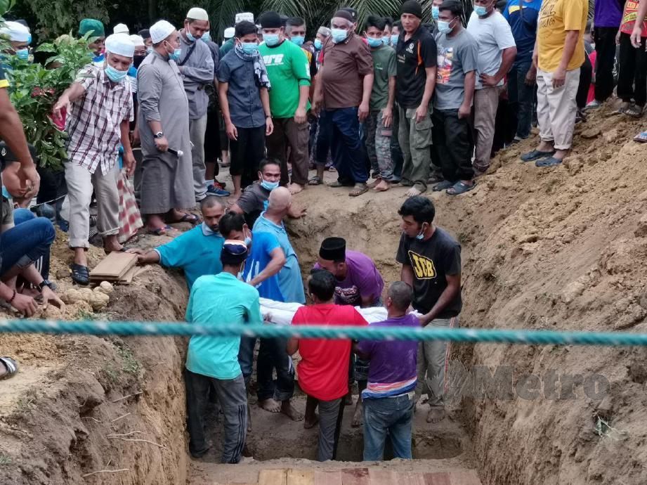 JENAZAH dibawa turun ke liang lahad di Tanah Perkuburan Islam Kampung Badlishah, Serdang. FOTO Nor Farhani Che Ad