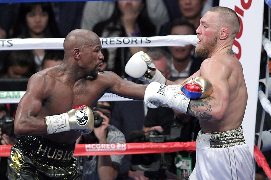 AKSI perlawanan antara McGregor (kanan) dan Mayweather. -Foto AFP
