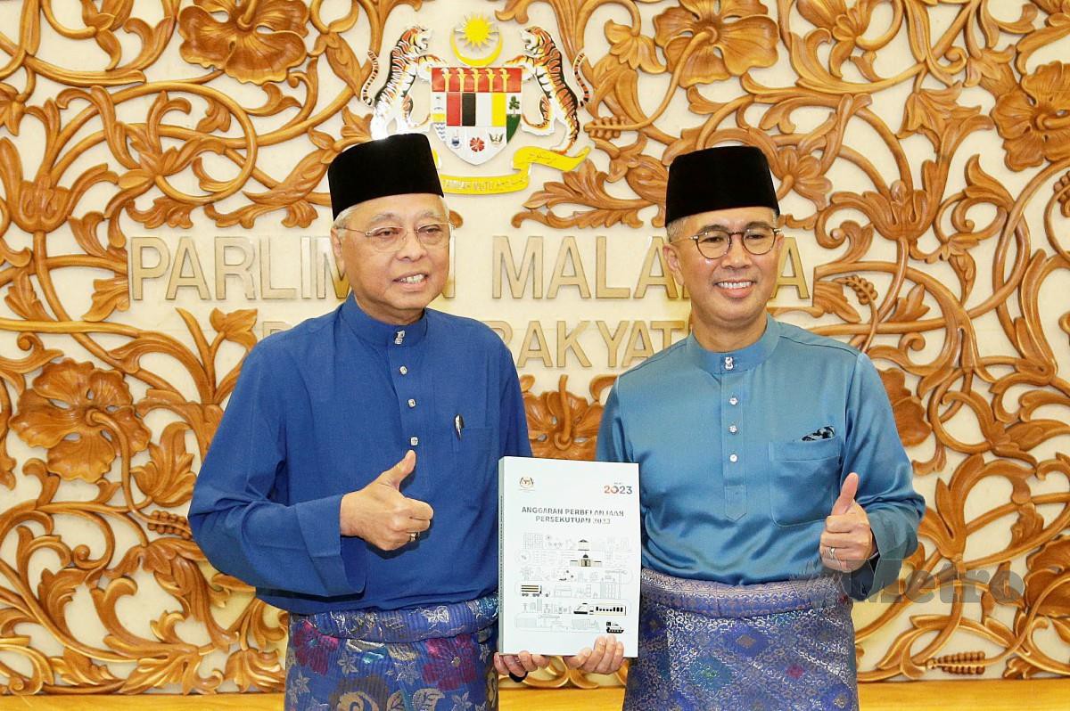 ISMAIL Sabri Yaakob bersama Tengku Zafrul menunjukkan buku laporan Bajet 2023 selepas pembentangan di Dewan Rakyat, hari ini. FOTO Aizuddin Saad.