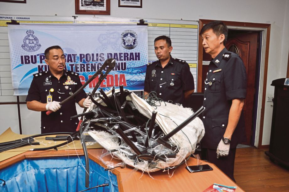  Suffian  (kiri) menunjukkan alat pemotong kabel yang digunakan anggota Geng Awang Cenneh  di IPD  Kuala Terengganu, semalam.