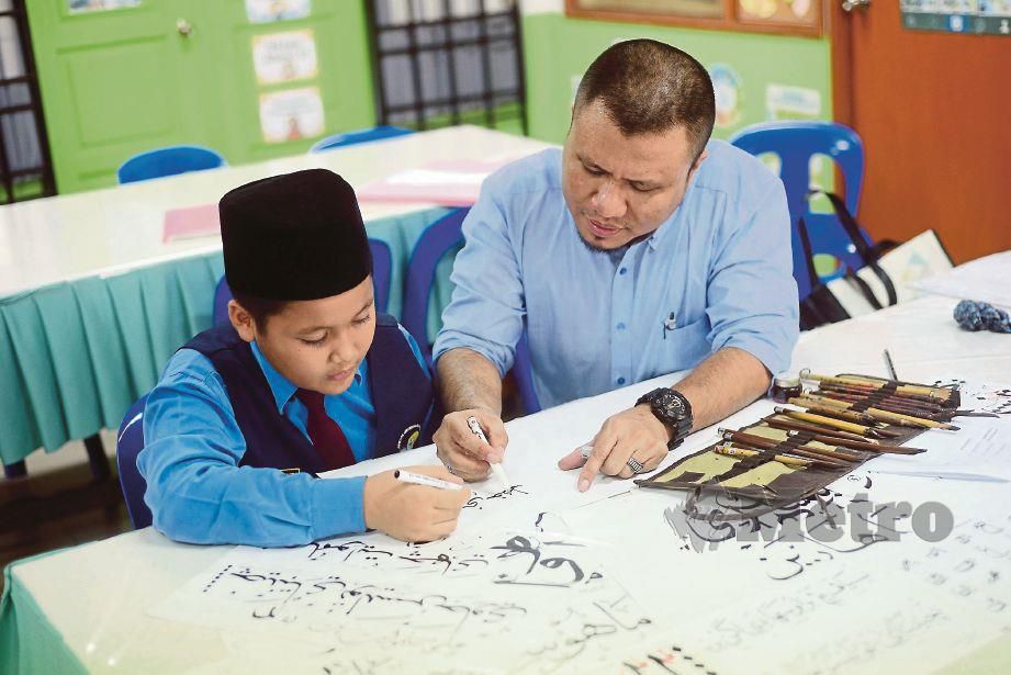  MUHAMMAD Anis  mengajar  Muhammad Hazim  menulis tulisan khat.