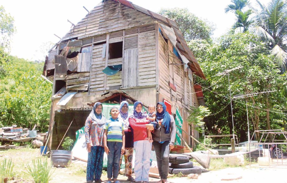  Zauyah (kiri) bersama anak dan cucunya di hadapan rumah mereka di Kampung Pulau Sayak, Kota Kuala Muda.