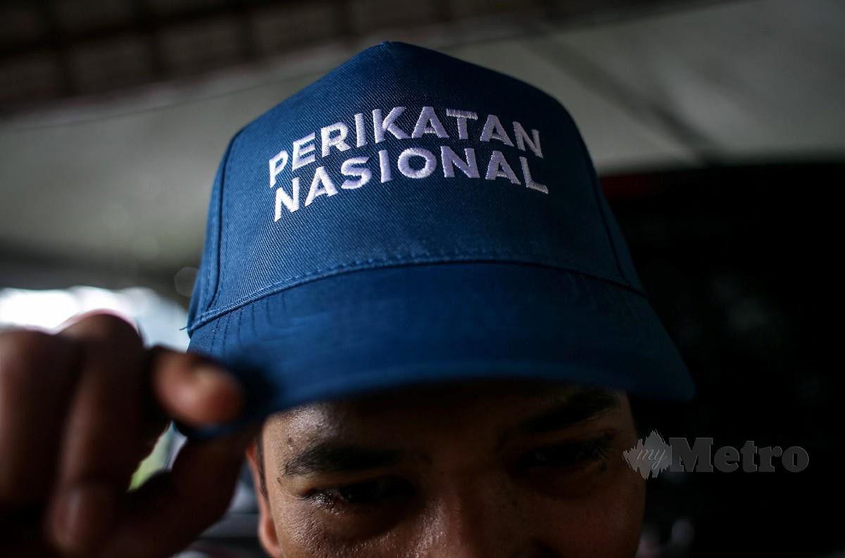 ANGGOTA jentera Perikatan Nasional (PN) memakai topi PN ketika tinjauan di Pusat Khidmat Dun Lunas, Padang Serai. FOTO Luqman Hakim Zubir.