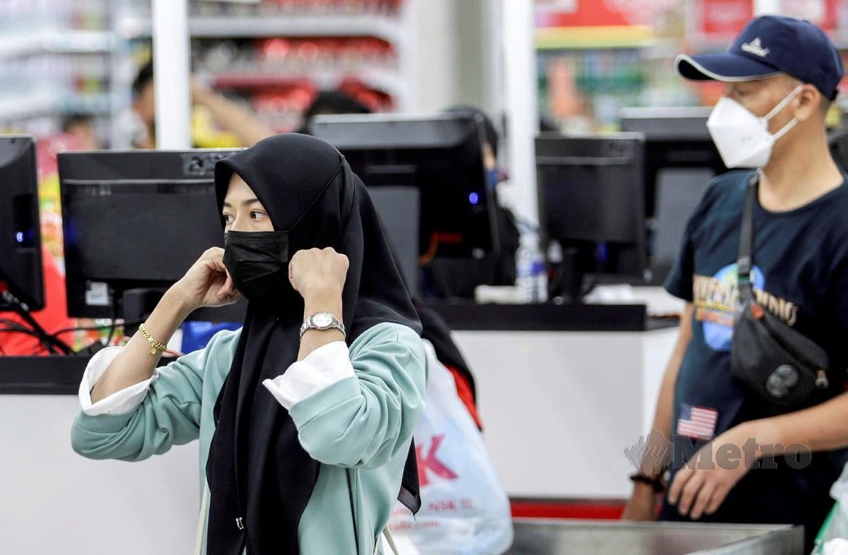 ORANG ramai memakai pelitup muka ketika membeli barangan keperluan harian di pasar raya di Seri Kembangan. FOTO Aizuddin Saad.