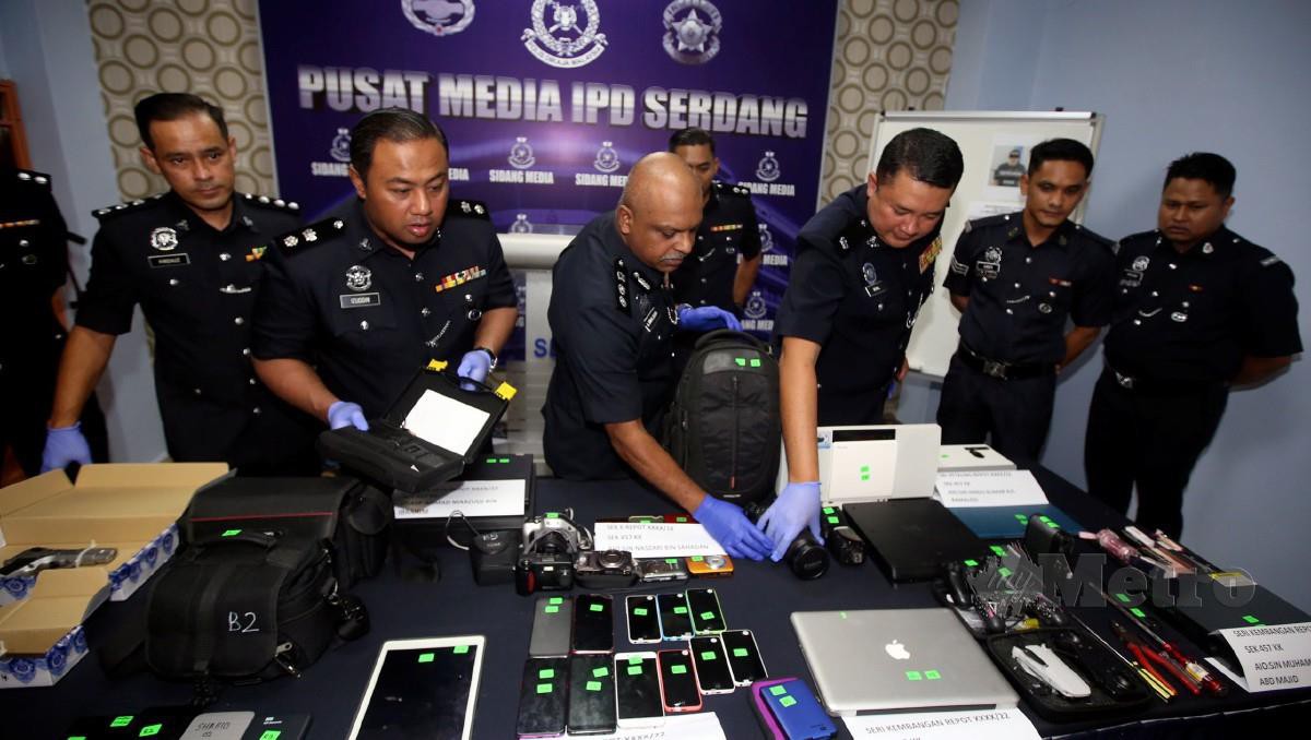 Anbalagan (tengah) bersama pegawainya melihat sebahagian barang rampasan pada sidang media di IPD Serdangkomputer riba dan telefon bimbit yang dirampas ketika sidang media di IPD Serdang. FOTO Hairul Anuar Rahim.