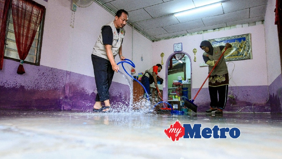 SUKARELAWAN Pertubuhan Bakti Ikhlas Malaysia (PERBAIK) membantu membersihkan kediaman mangsa banjir di Kampung Sungai Sintok selepas banjir mulai surut. FOTO Asyraf Hamzah