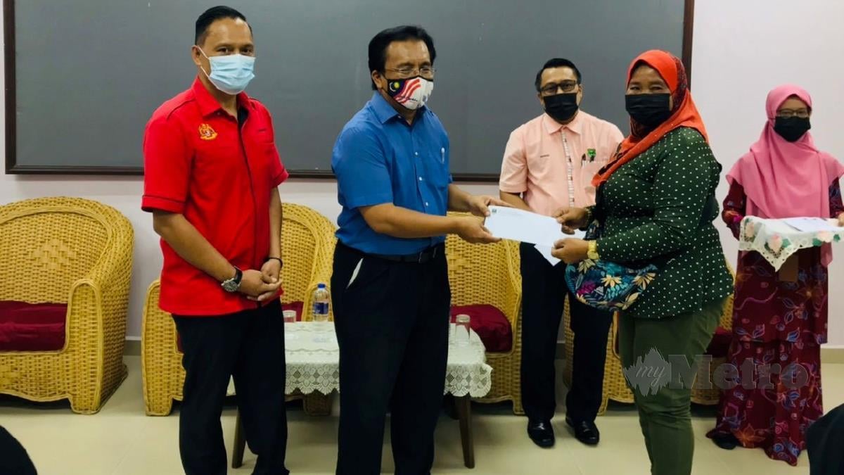 Pengerusi Tindakan Daerah Datuk Abdul Rahman Mohd Reza (dua kiri) menyampaikan sijil kepada peserta kursus disaksikan Muhamad (kiri). FOTO ihsan Kemas.