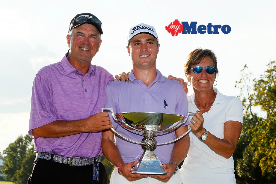 THOMAS (tengah) meraikan kejayaan menjuarai Piala FedEx bersama  ibu dan bapanya. - Foto AFP